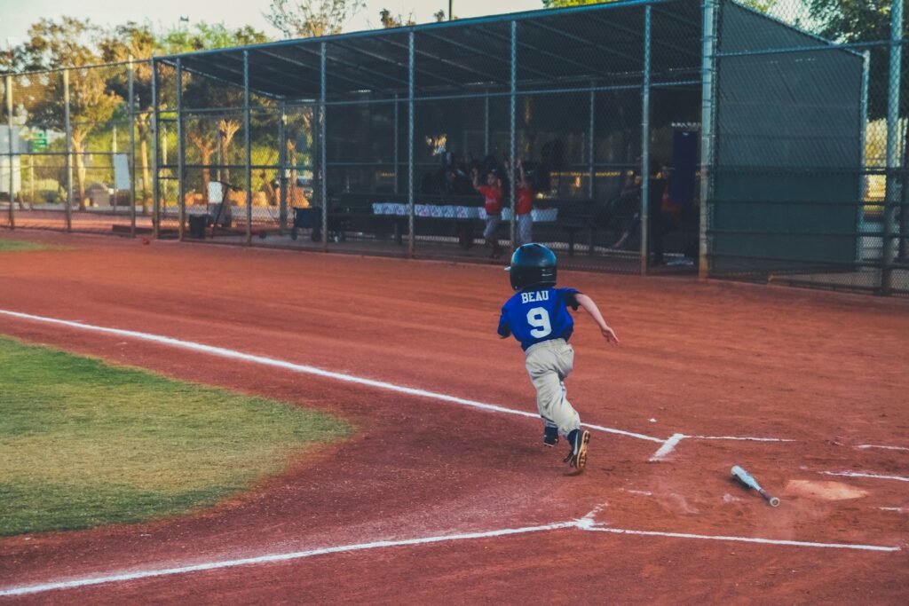 boy hit the ball running for the next base